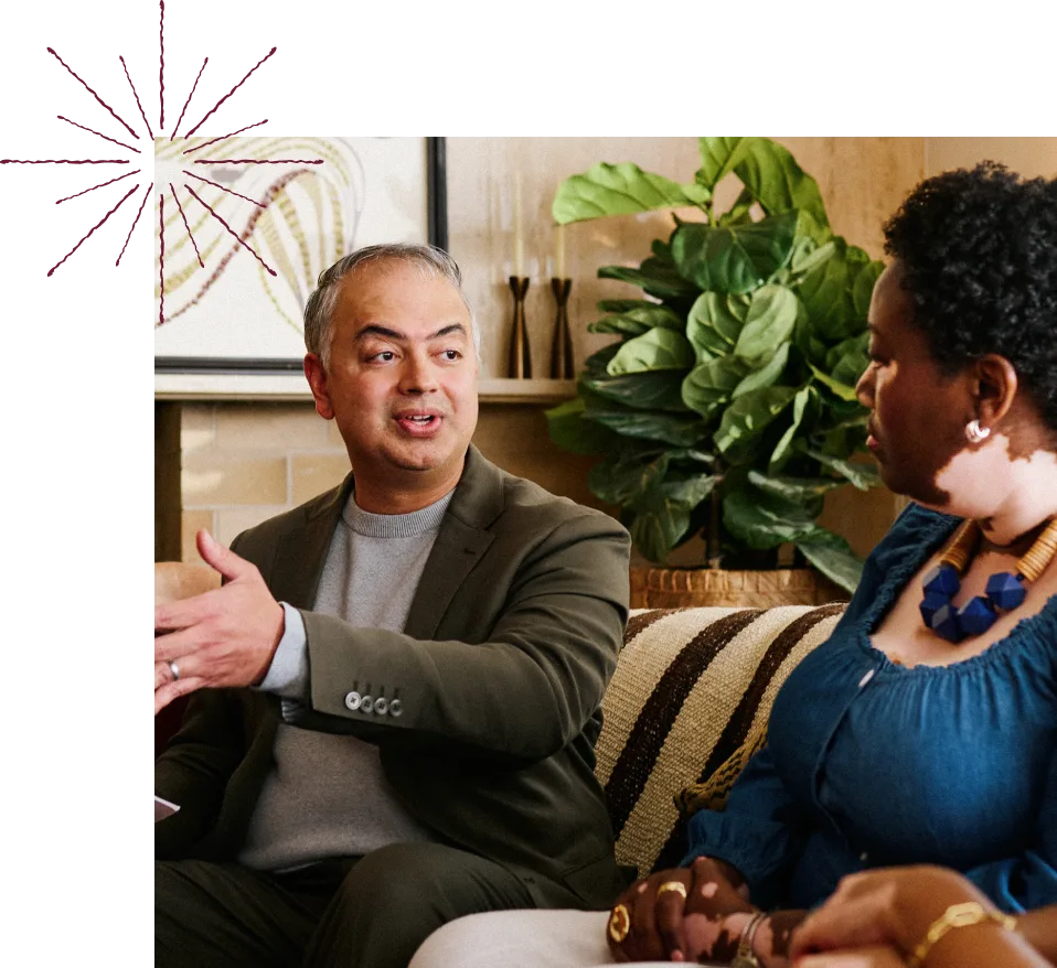 A man and a woman sitting on a couch, engaged in conversation