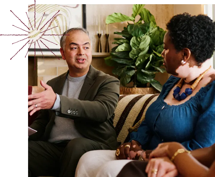 A man and a woman sitting on a couch, engaged in conversation